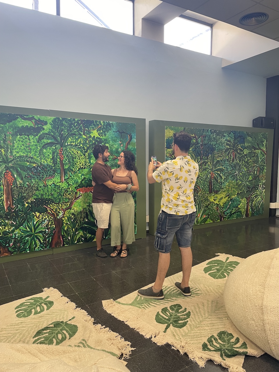 visitors photographing in front of jungle paintings — Biophilia & Art exhibition